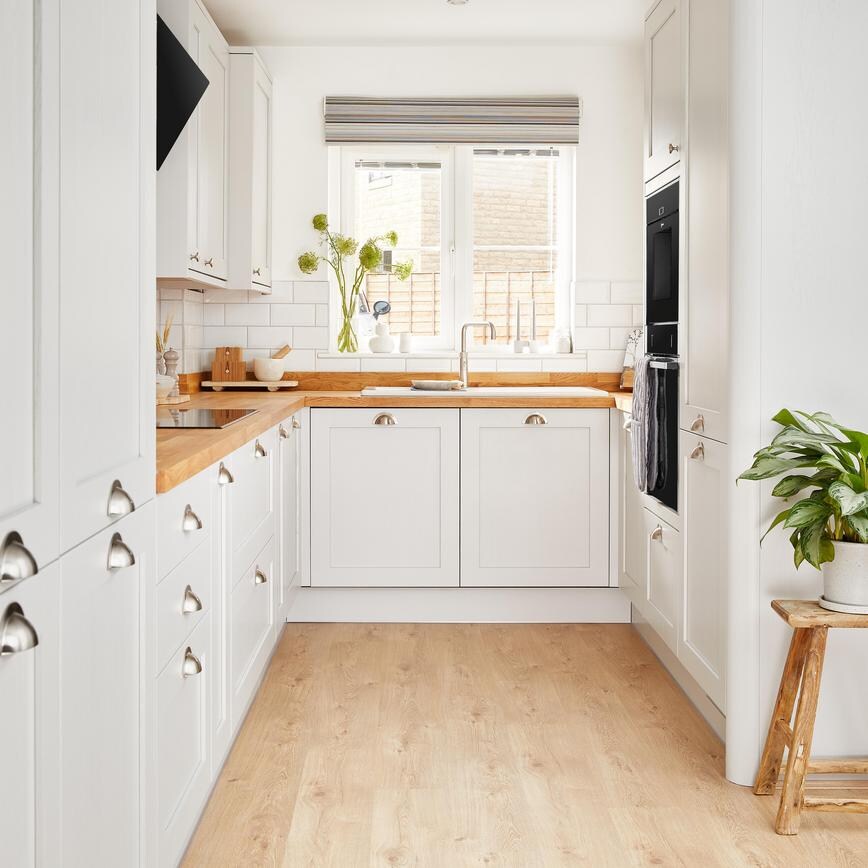 A wide shot of Ellen White's Howdens kitchen, with a pleasant plant and a bright window