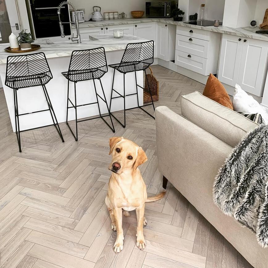 A white shaker kitchen idea with grey marble effect worktops and white wash herringbone timber effect floor. 