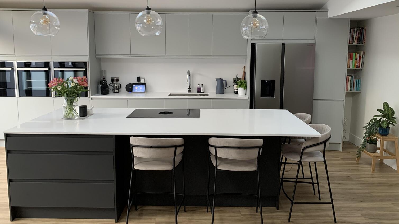 Kitchen island design with a two-tone layout, featuring a charcoal integrated handle island with stools.