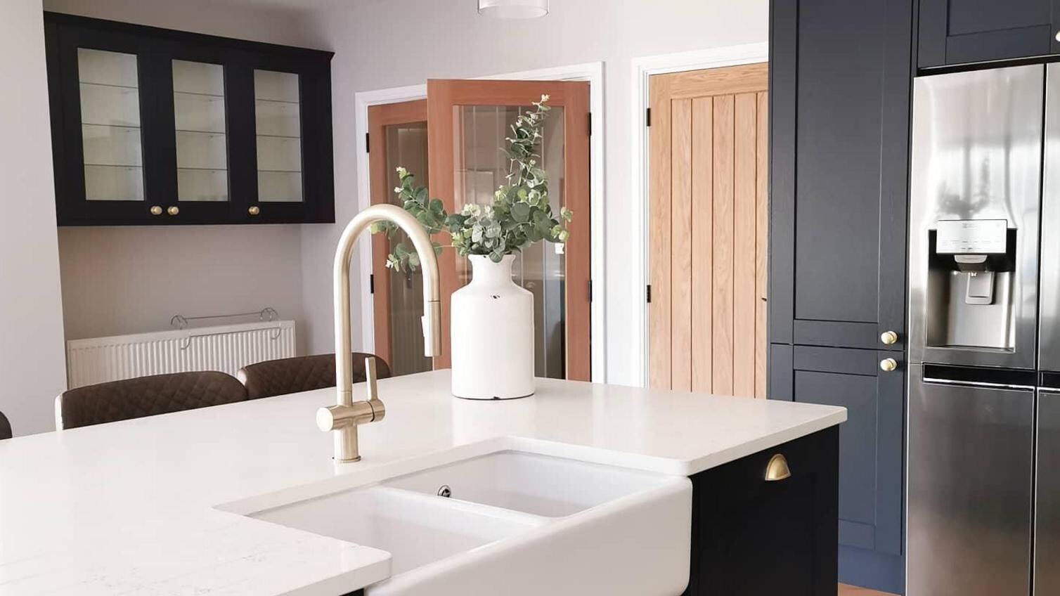 A dark blue shaker kitchen, with a Belfast double sink and oak kitchen door.