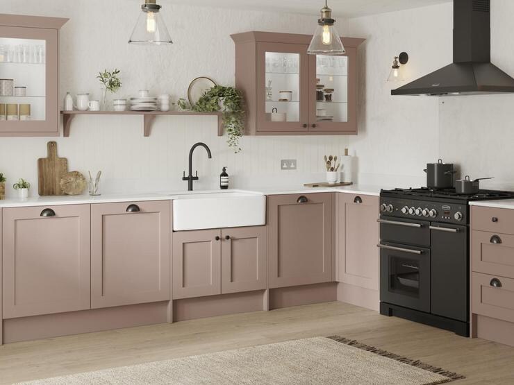 A pink shaker kitchen with a bright aesthetic and wooden floor