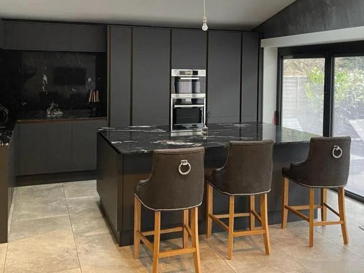 A solid black kitchen in a modern room