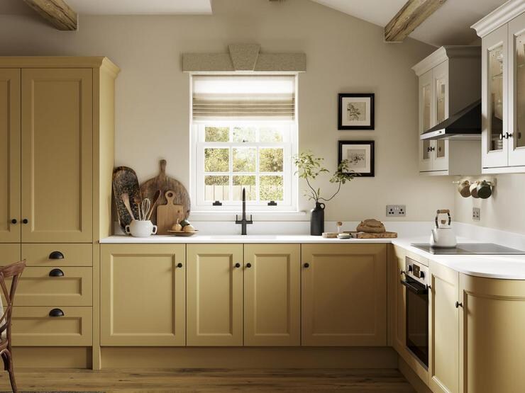A shaker kitchen in a large room, with a muted, yellow tone