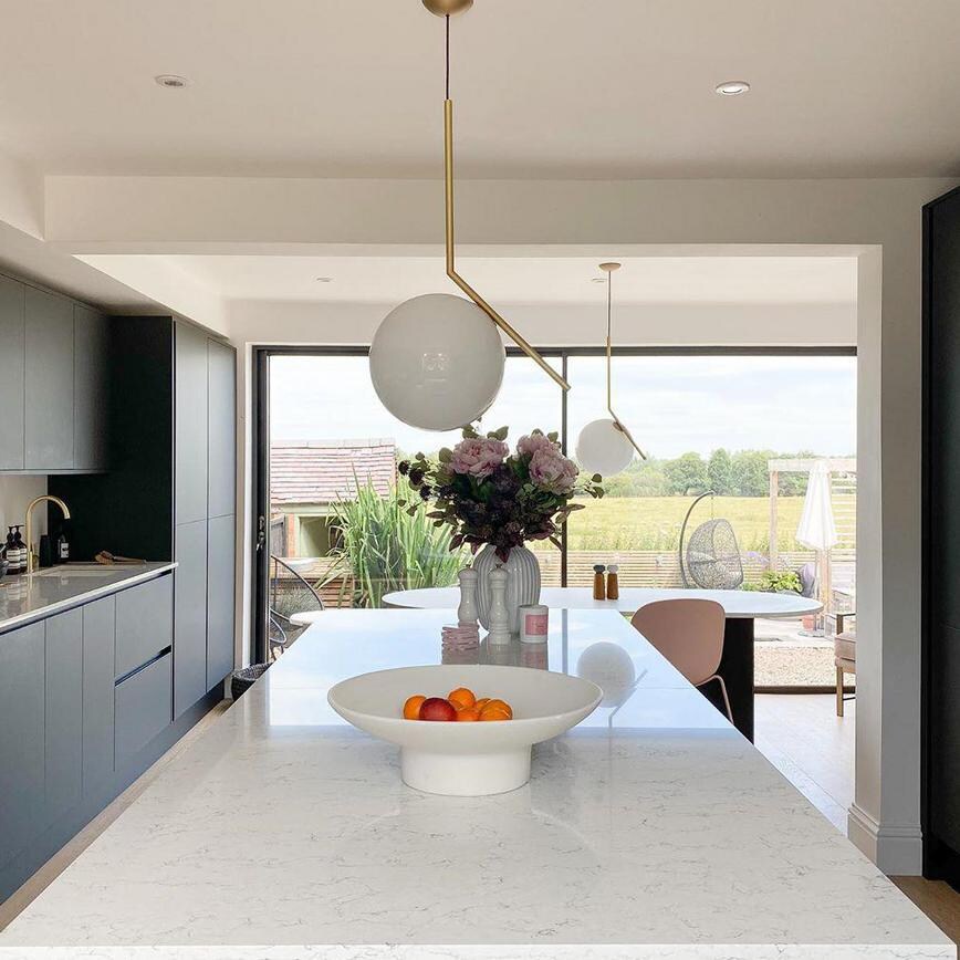 Black handleless kitchen design with a matt finish and luxury style using marble-effect quartz counters