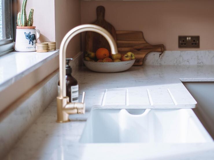 Brushed brass kitchen tap with a curved spout and single lever design