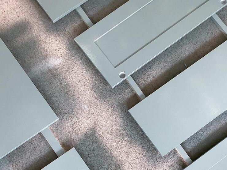 Birds eye view of shaker doors lying side by side on the floor, showing how they have been freshly painted in a teal shade.