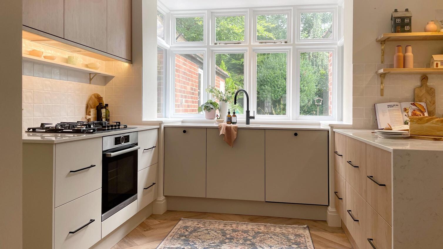 Simple neutral kitchen with slab doors and black bar handles