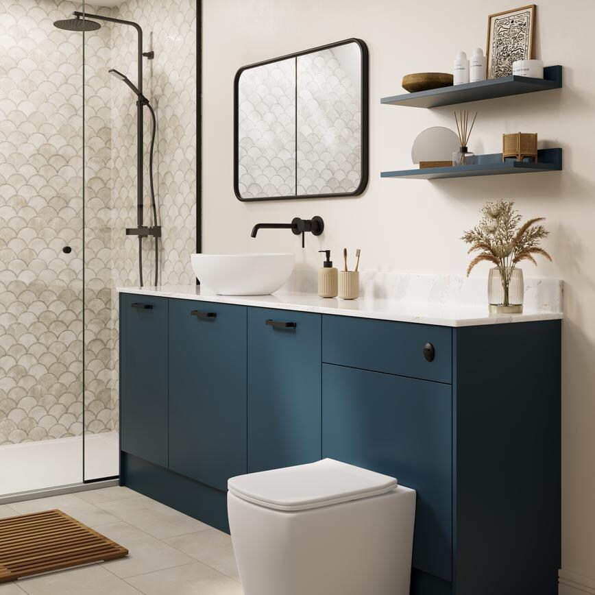 A marine blue bathroom with white countertop and matching upstand. There is a white toilet, shower, and grey tiled flooring.