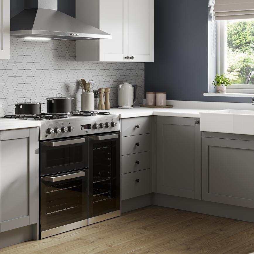 XPIRED_A grey shaker kitchen design with contemporary features such as a white worktop, small Belfast sink, and chrome fixtures.
