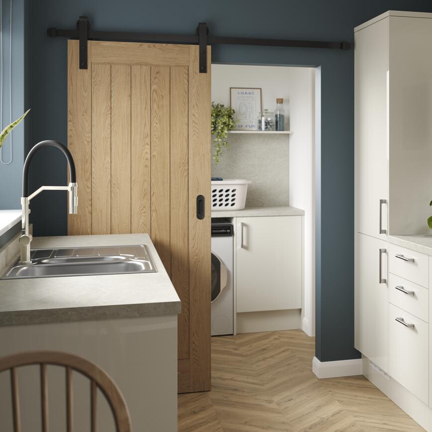 A porcelain, slab kitchen with a gloss finish in a galley layout. It has oak-effect flooring, integrated appliances and hob.