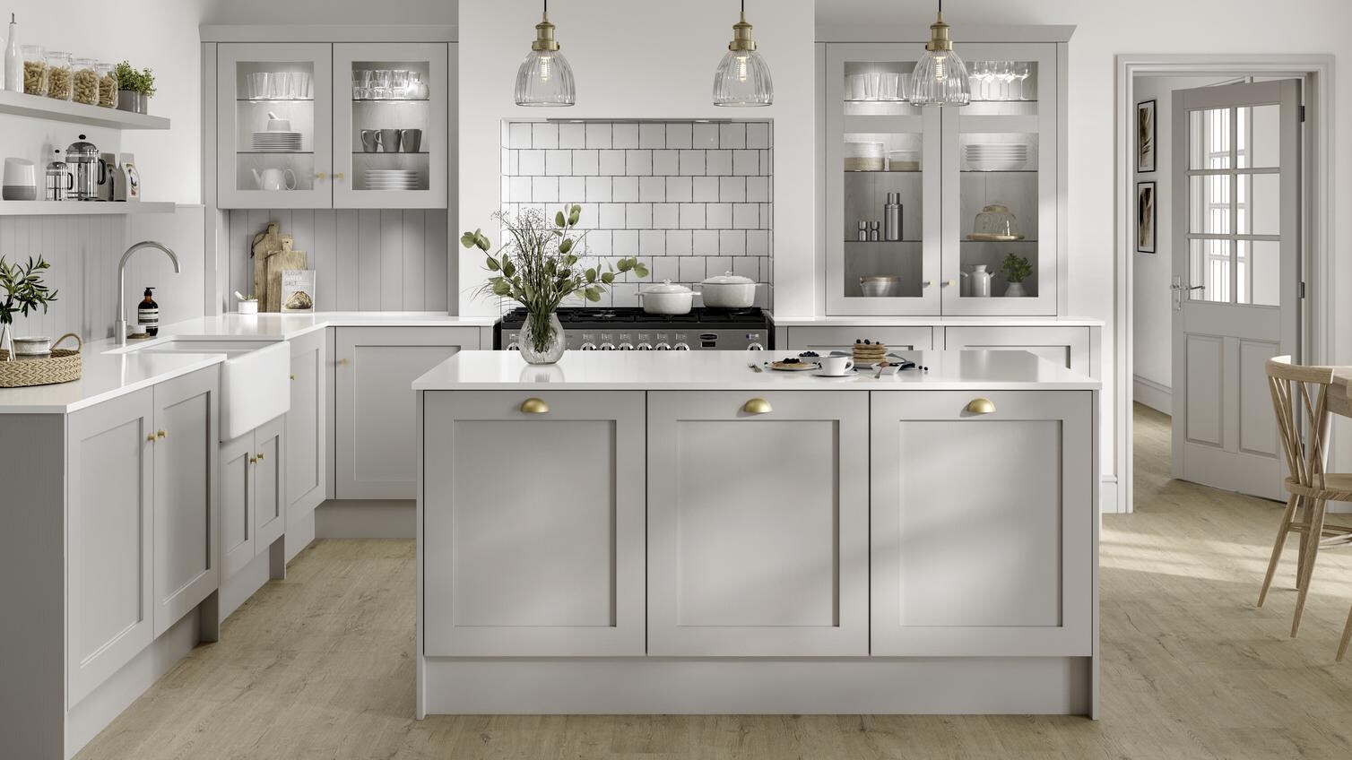 Country style dove grey shaker kitchen in kitchen island layout. Recessed oven area with square white brick tiles.