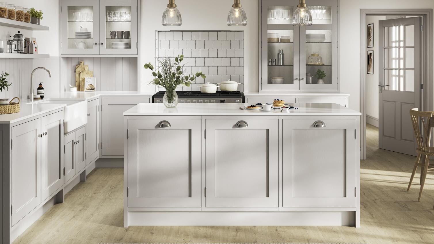 Grey shaker kitchen with an in-frame design in an island layout. Contains exposed hinges, chrome handles, and white worktops.