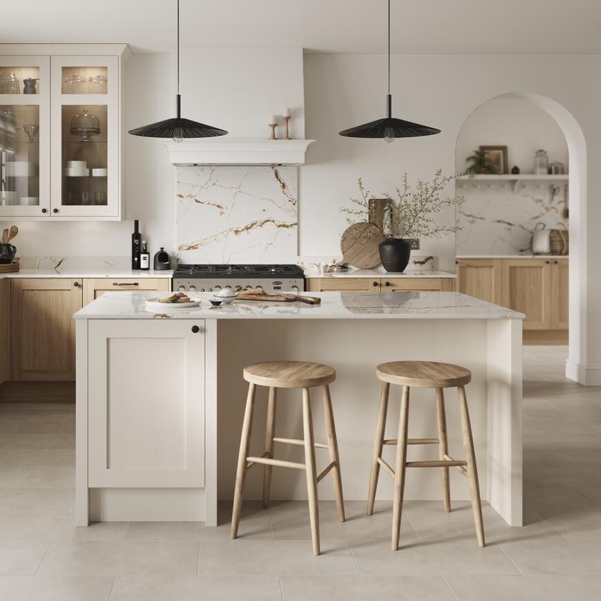 An oak l-shaped kitchen with a white shaker island. It has stone-effect flooring, range cooker, and electric hob.