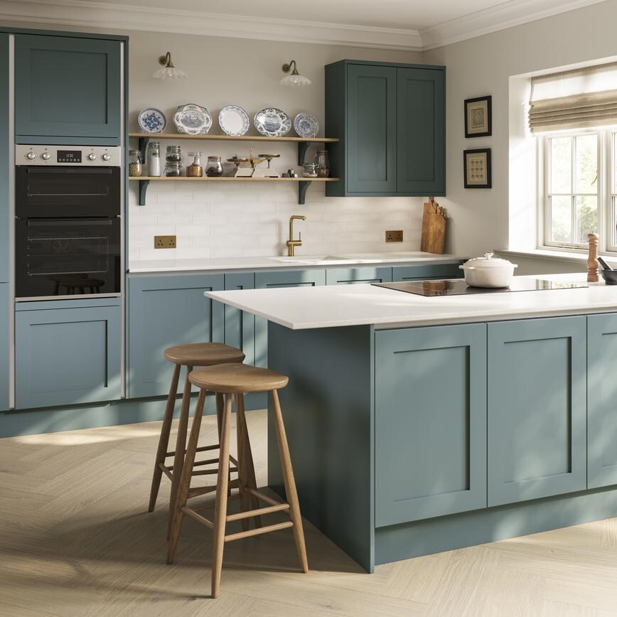 Blue shaker cupboard doors with silver profiles for a classic scheme. Has white worktops and wood flooring for a costal look.