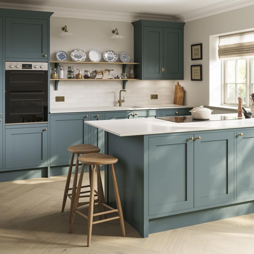 Blue kitchen idea featuring shaker doors in a peninsula layout. Has white worktops and timber floors for a seaside theme.