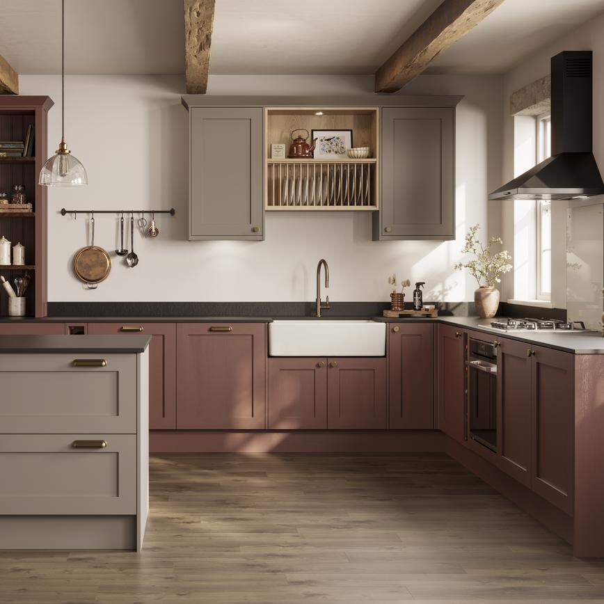 An earth red shaker kitchen in a peninsula layout. It is finished with black stone work and oak-effect panel flooring. 