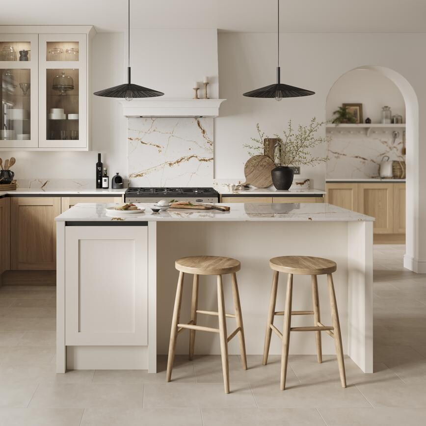 A handleless kitchen featuring oak and white shaker cabinets. It has quartz worktops, marble splashback, and stone flooring.