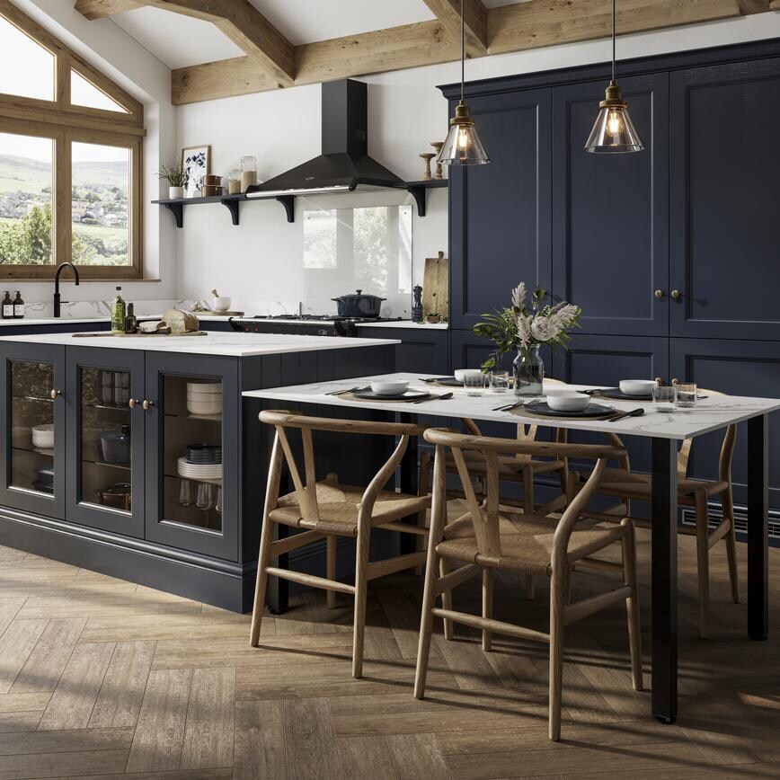 Navy shaker doors with a beaded detail in an island layout. Includes a black extractor, white worktops, and tower units.