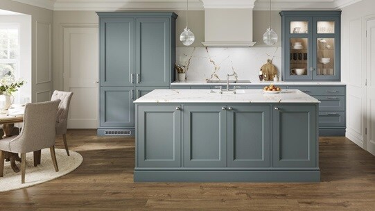 A blue shaker kitchen with in-frame doors in single wall and island layout. Finished with curved cabinets, white worktops.
