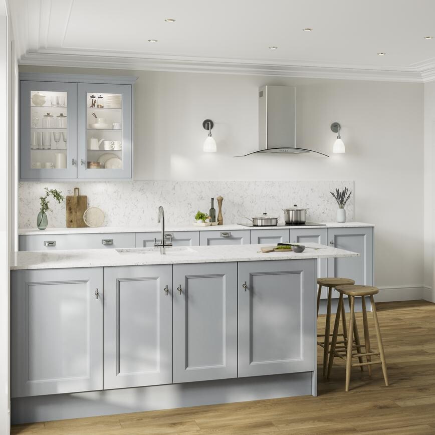 A peninsular kitchen, in a mist blue colour and shaker design. It has white worktops, black appliances, and glass wall units