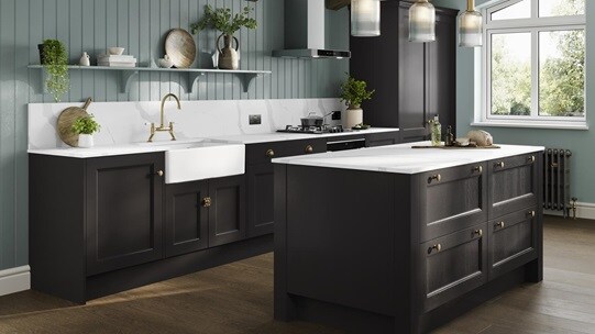 A black shaker kitchen in an L-shaped layout with a dusk blue island. There are black worktops and dark oak flooring. 