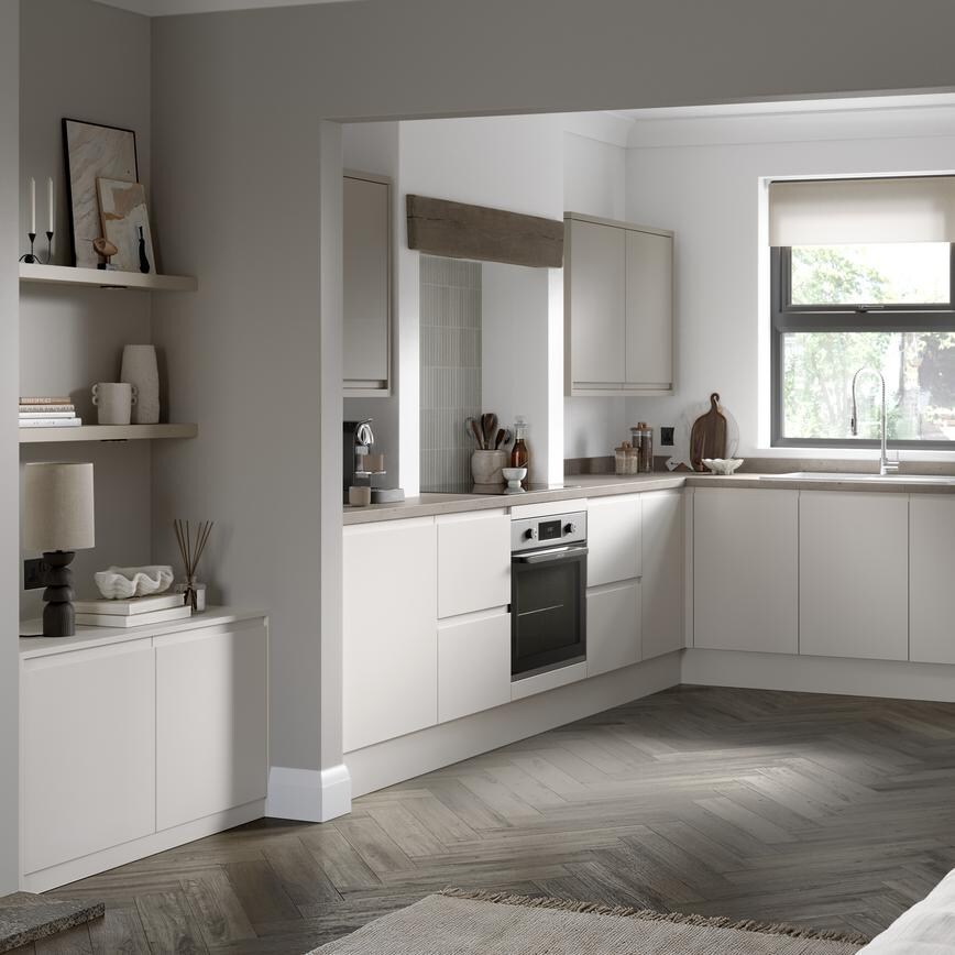 Open-plan kitchen and living room from Clerkenwell Super Matt Porcelain. It has oak herringbone flooring and stone worktops. 