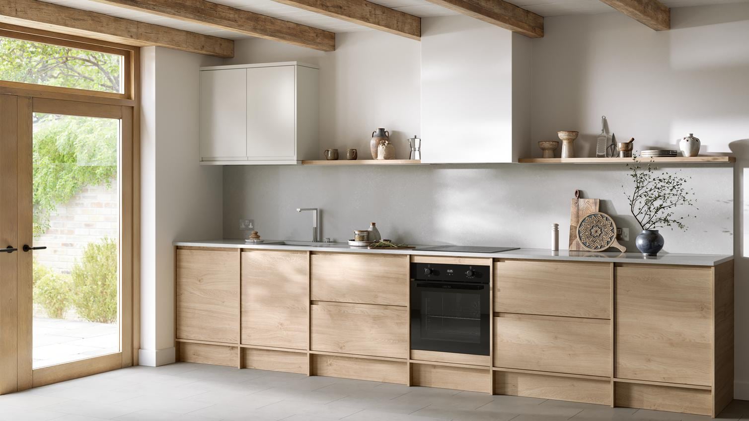 Natural oak kitchen from the Clerkenwell collection. It is in a single-wall layout with tiled flooring & white wall cabinets.