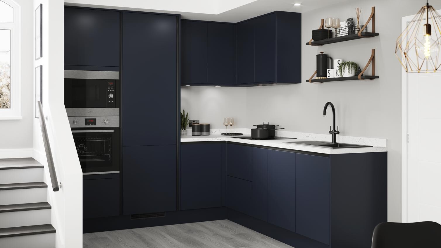 Handleless blue kitchen idea with navy doors and copper trims in an L-shaped layout. Has grey wood floors and white worktops.