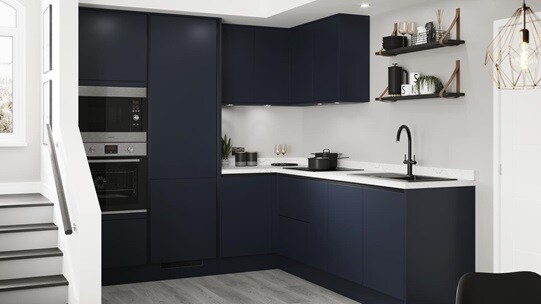 Handleless blue kitchen idea with navy doors and copper trims in an L-shaped layout. Has grey wood floors and white worktops.