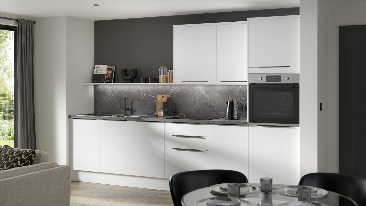 A gloss white Greenwich kitchen in a single-wall layout & chrome handles. It has oak effect flooring & black marble surfaces.