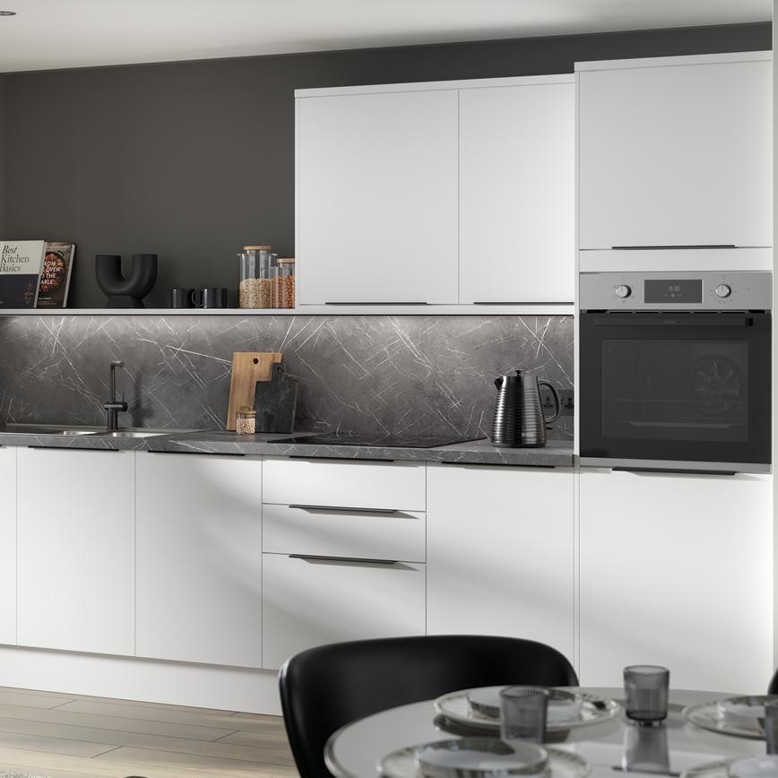 A gloss white Greenwich kitchen in a single-wall layout & chrome handles. It has oak effect flooring & black marble surfaces.