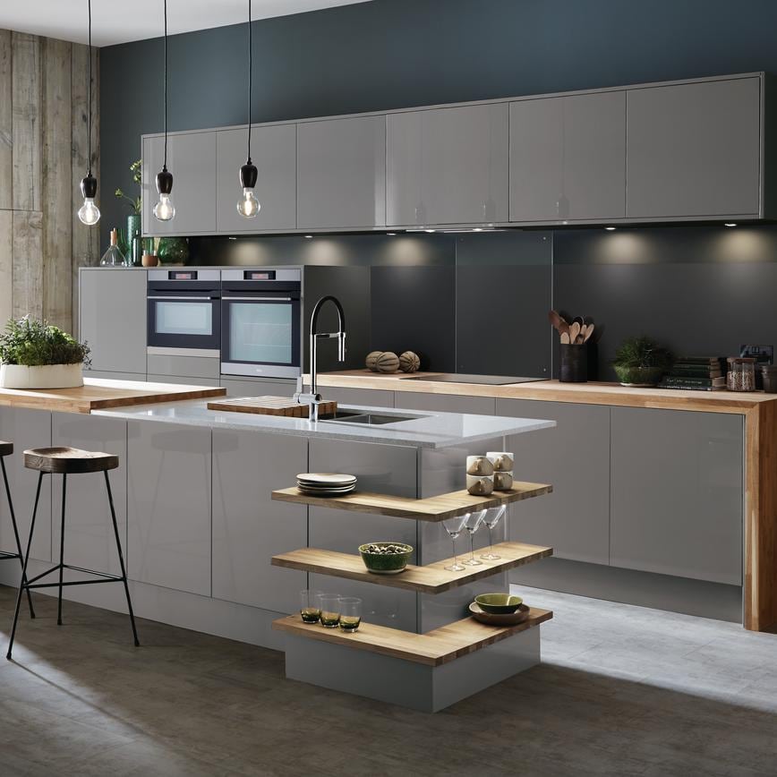 Slate grey gloss kitchen with island unit incorporating wrap around open shelves and breakfast bar with mirror chip worktop.