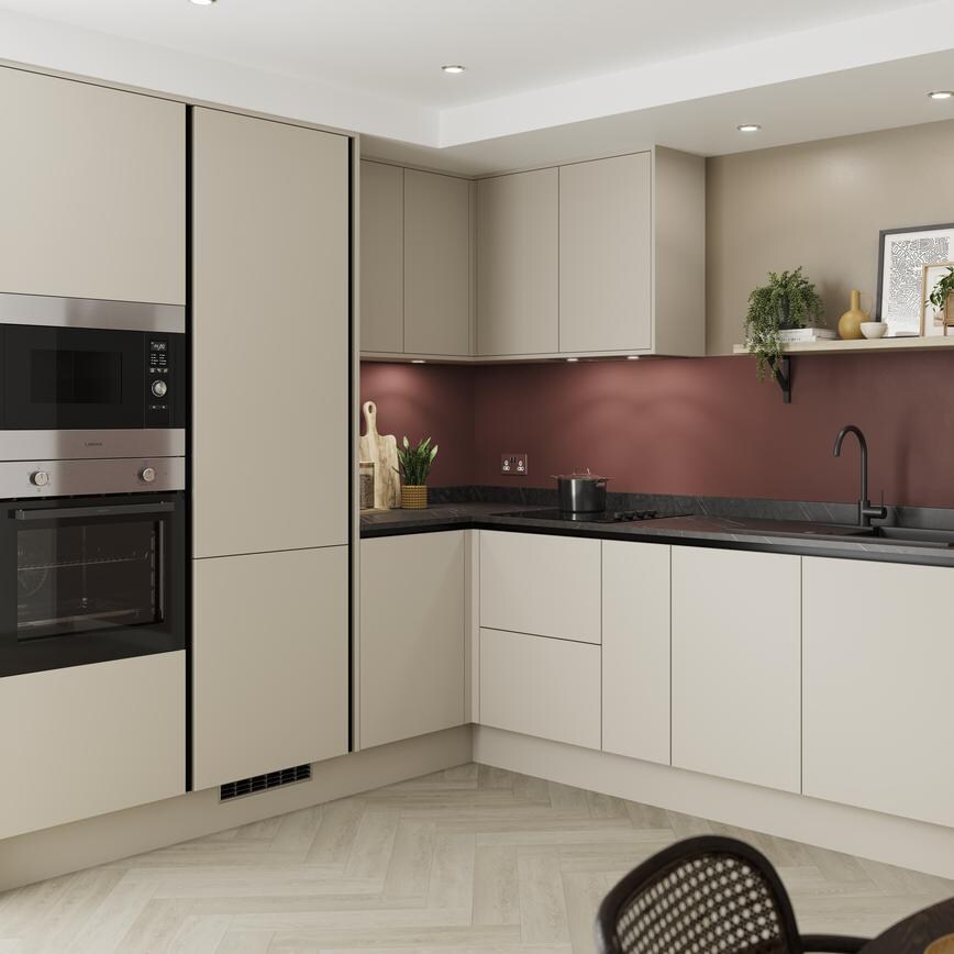 A modern sandstone kitchen design with matt, integrated handle doors, tower devices, black profiles, and a matt black tap