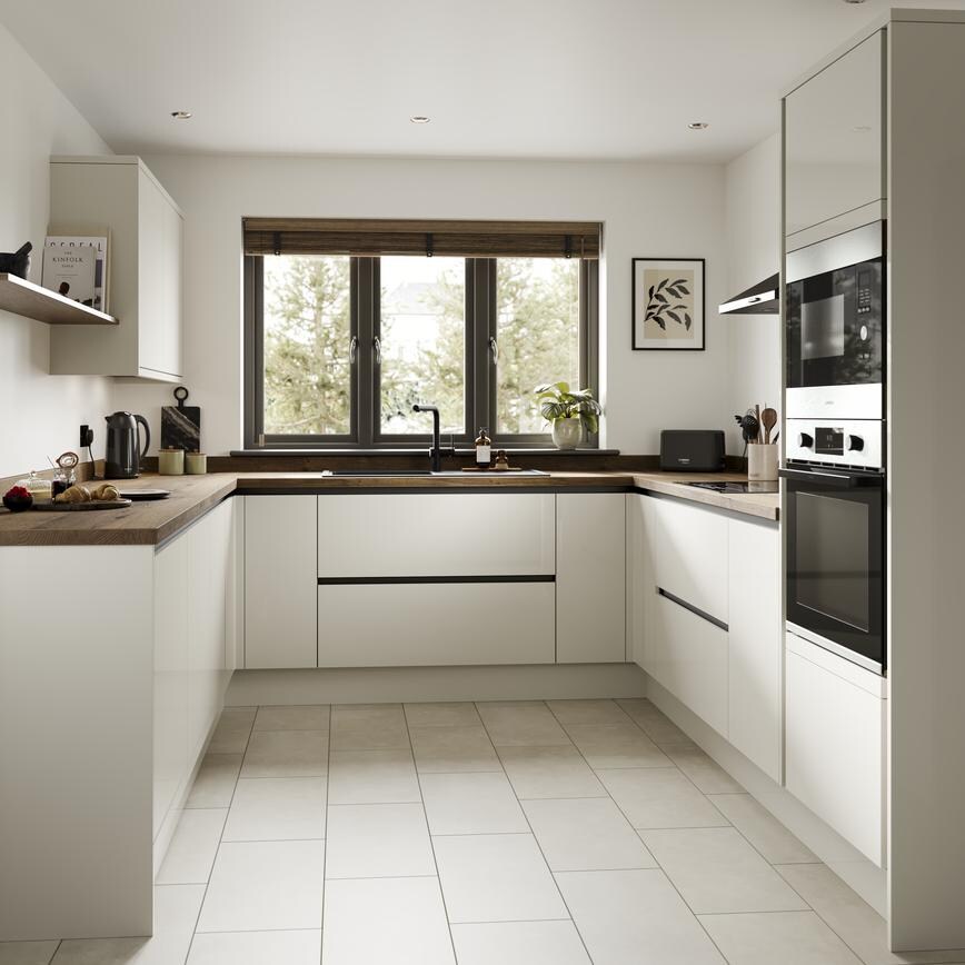 A porcelain, slab kitchen in a gloss finish and u-shaped layout. It has dark worktops, handleless doors and black profiles. 