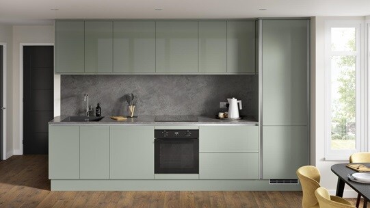 A single wall reed green kitchen, in a gloss finish. It has handleless doors, dark stone backsplash, and dark oak flooring.