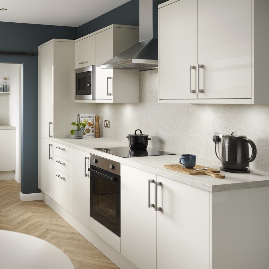 A porcelain, slab kitchen with a gloss finish in a galley layout. It has oak-effect flooring, integrated appliances and hob.
