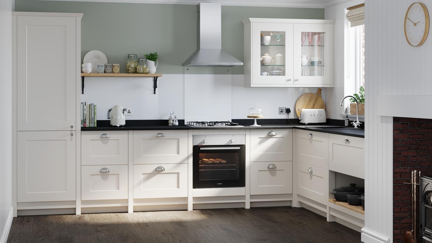 Classic cream shaker kitchen idea with ivory shaker doors in an L-shaped layout. Has silver cup handles and a built-in oven.