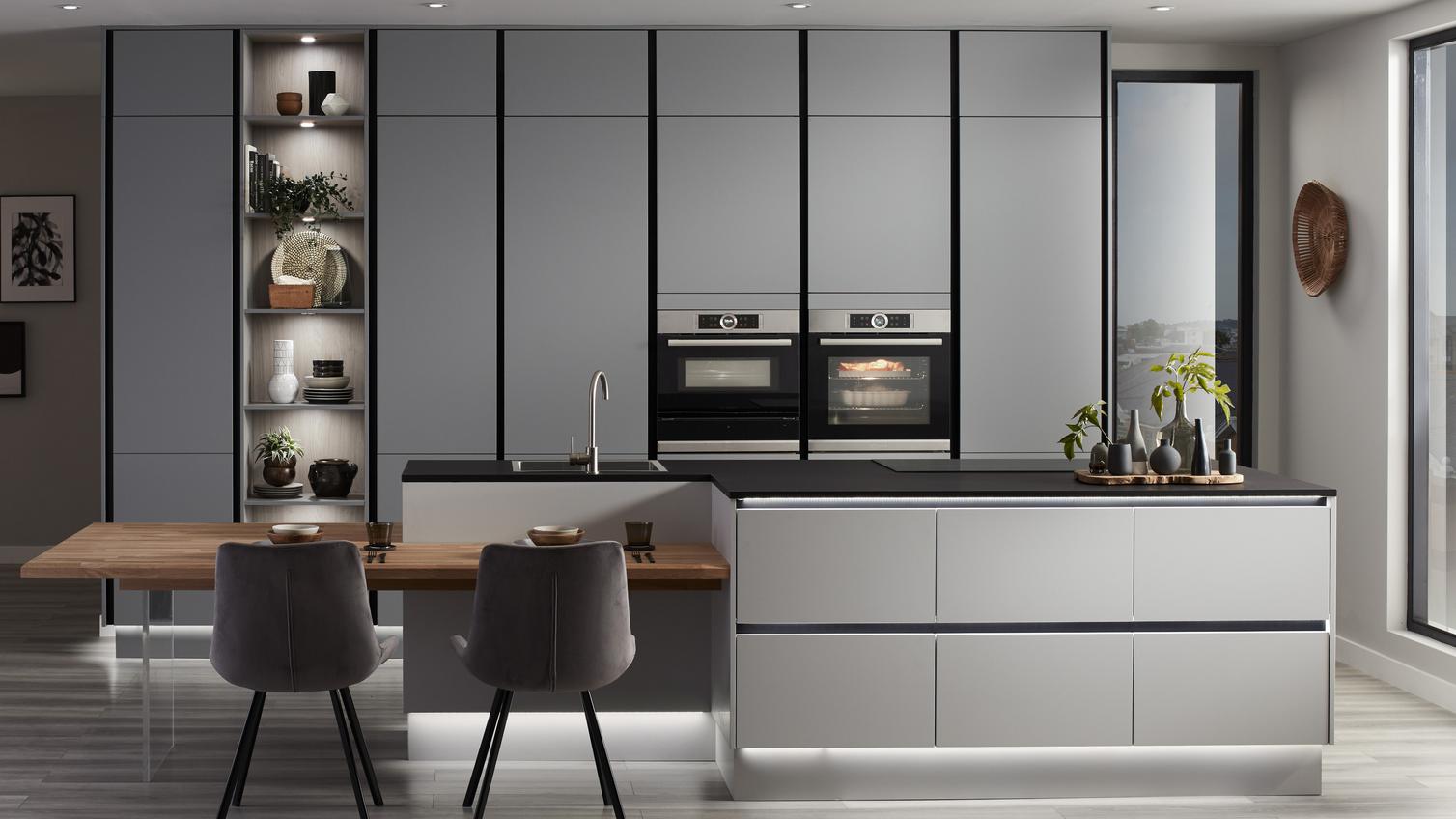 Super matt slate grey handleless kitchen with p shaped kitchen island unit, black kitchen worktop and integrated black trims.