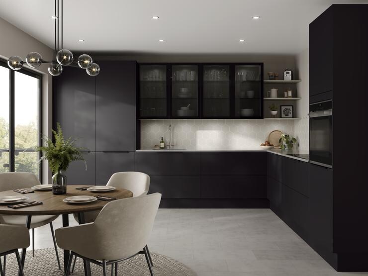 L-shape black kitchen idea with super-matt slab doors, glass wall cabinets above a white worktop, and a chrome kitchen tap.