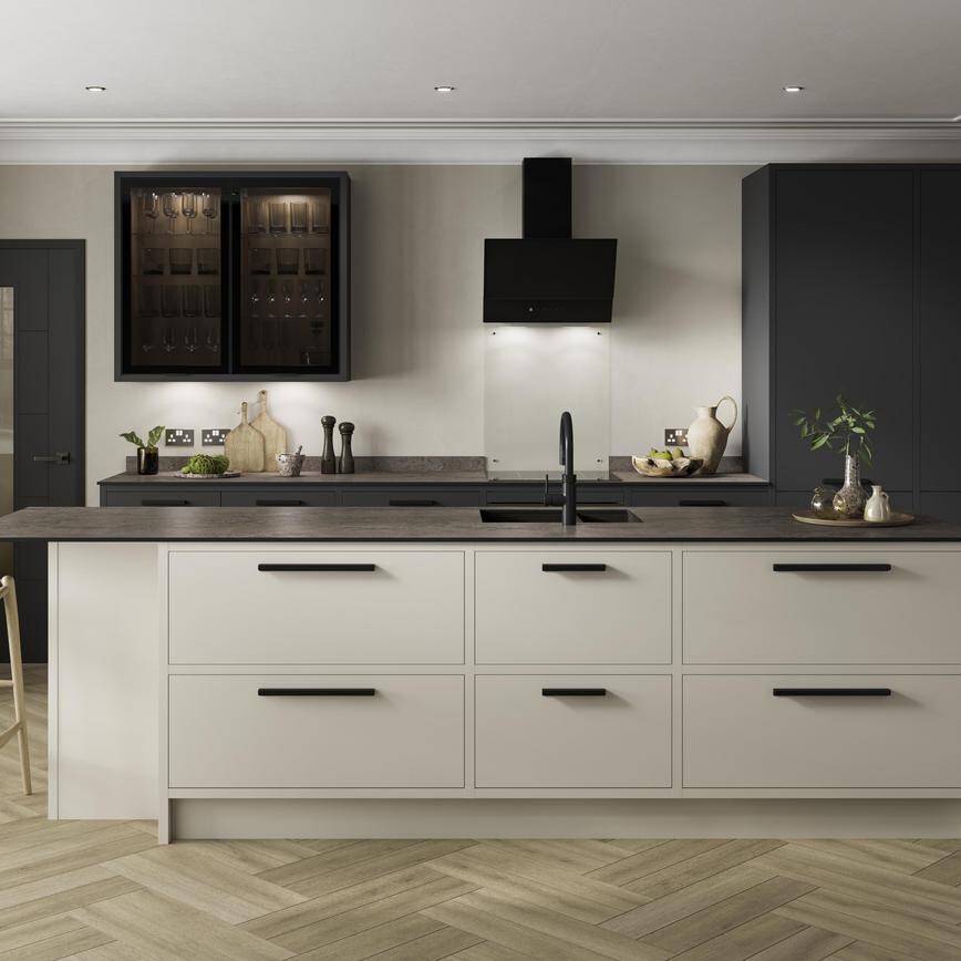 A charcoal and sandstone kitchen design with an island featuring an in-frame border, black bar handles, and a black tap.