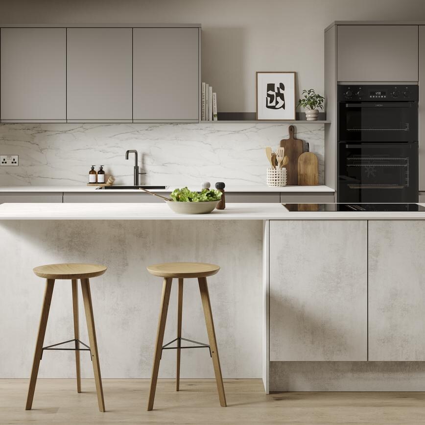 A slab, white stone kitchen in a single-wall layout with a textured finish. It has oak wall cabinets and a white worktop. 