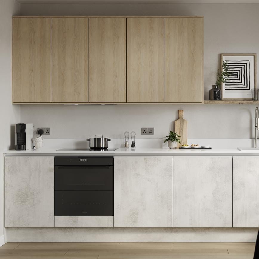 A slab kitchen island layout in a textured white stone finish. It also has grey cabinets on one wall & marble-style surfaces.