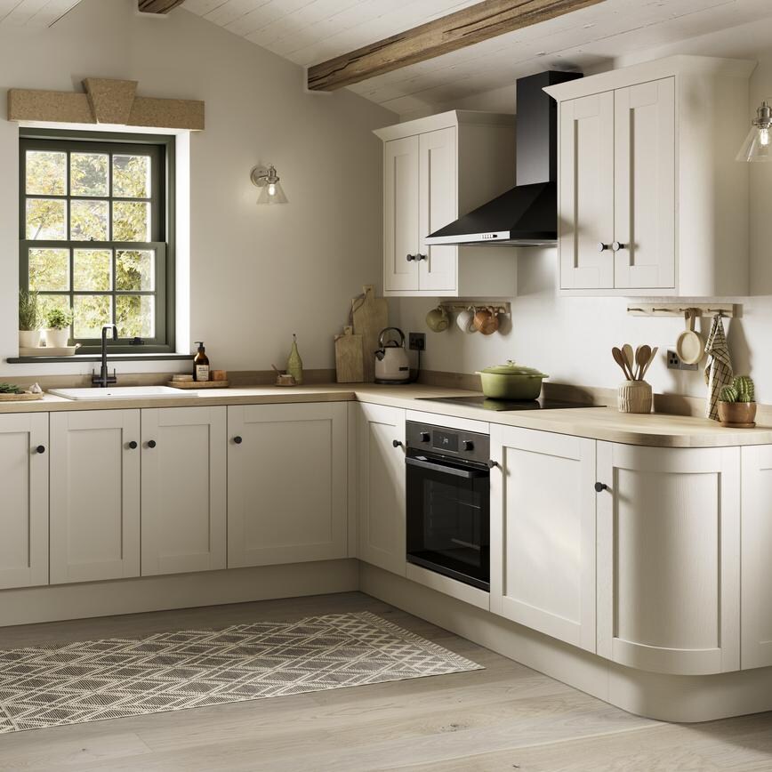 A white, shaker kitchen from the Halesworth porcelain range. It is in an l-shaped layout and features curved cabinet doors