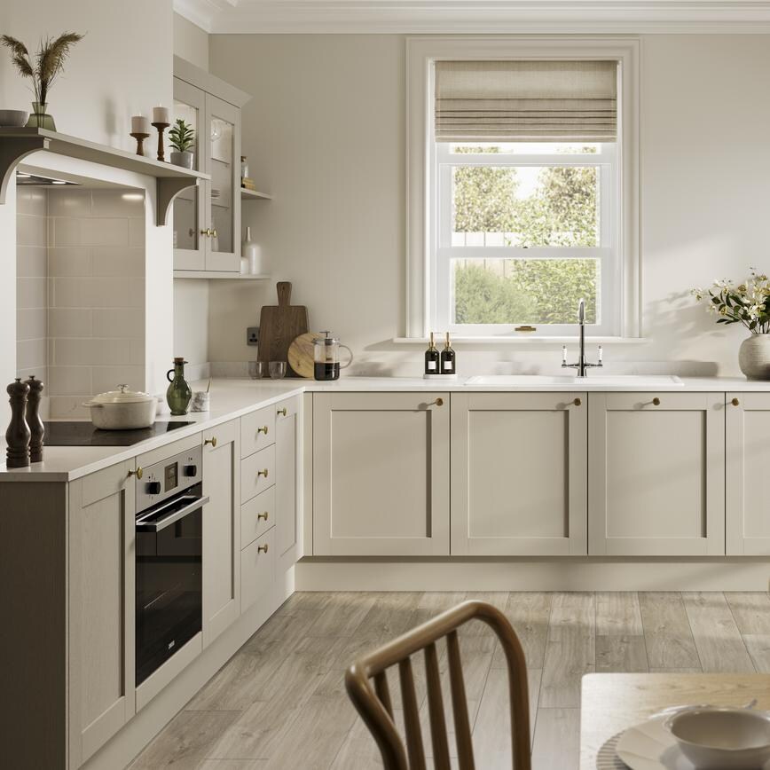L-shaped, shaker kitchen in a cream, pebble colour. From the Halesworth range. Features white worktops and oak flooring