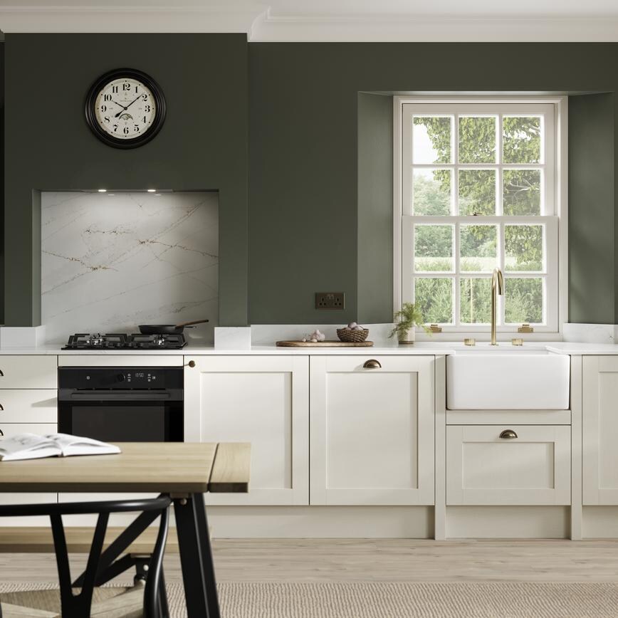 A cream, shaker kitchen in a single-wall layout. Features light oak flooring, ceramic sink, and brass tap and accessories.