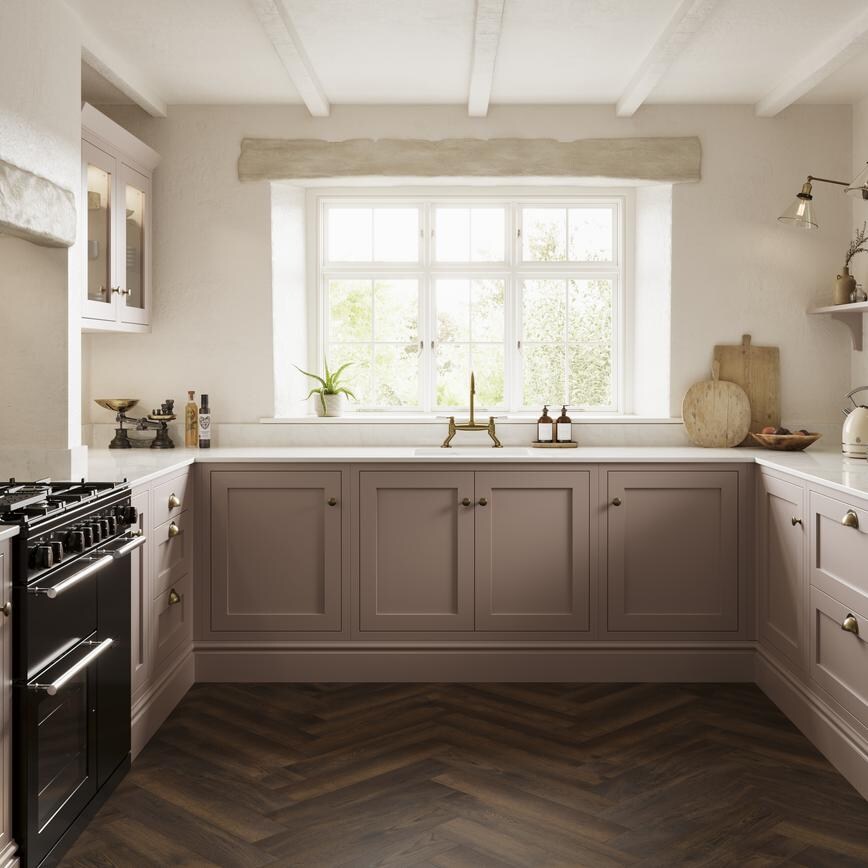 A pink shaker kitchen, in an antique rose shade from the Ilfracombe collection. It has dark oak herringbone flooring.