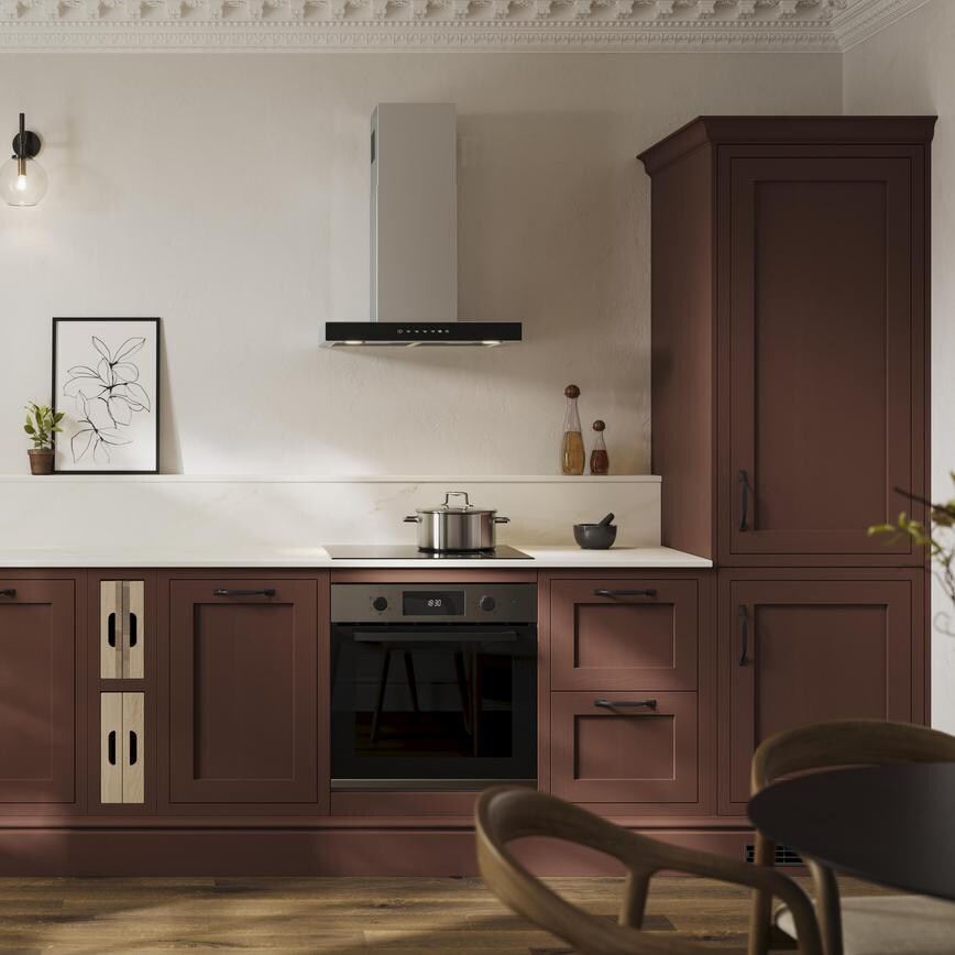 An earth red shaker kitchen from Ilfracombe in a single-wall layout. It has black accessories and a marble-style worktop.