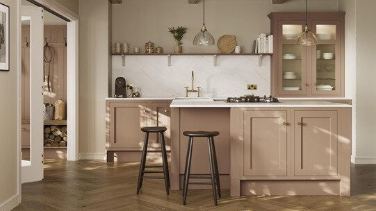 An orange shaker kitchen from Ilfracombe Terracotta, in a single wall layout. It has an island and herringbone, oak flooring