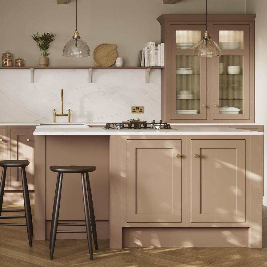 An orange shaker kitchen from Ilfracombe Terracotta, in a single wall layout. It has an island and herringbone, oak flooring