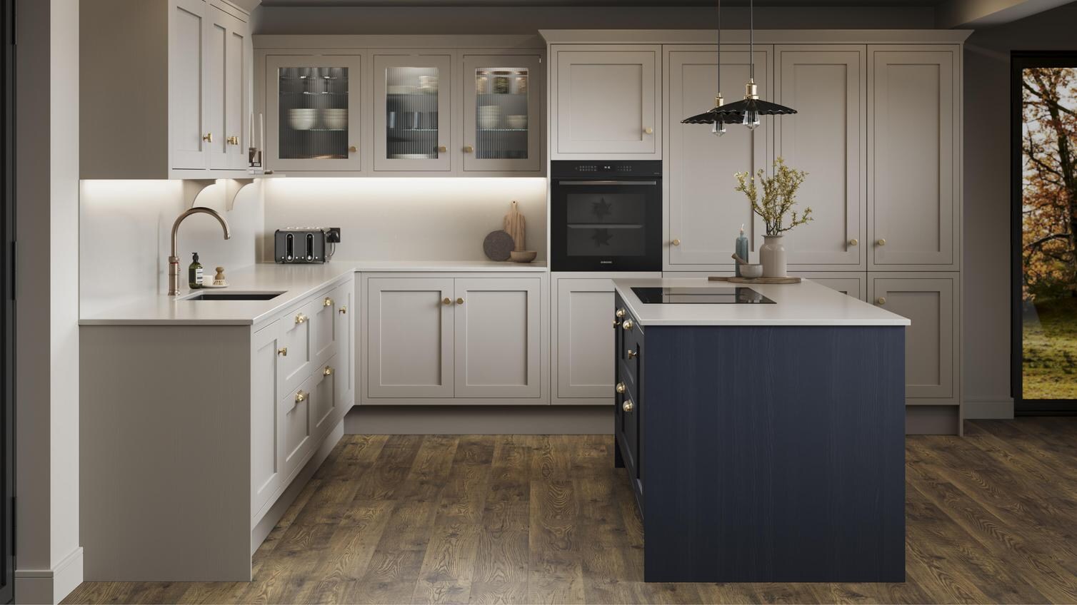 A pebble shaker kitchen from Ilfracombe, in an l-shaped layout and a navy-toned island. It also has dark oak flooring. 